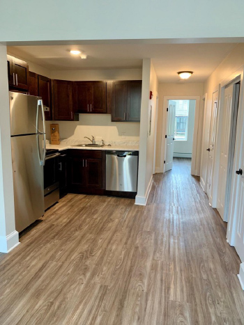 Photograph of the interior of an unfurnished kitchen with appliances.