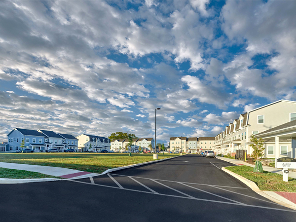 Image of apartment buildings surrounding a central lawn.