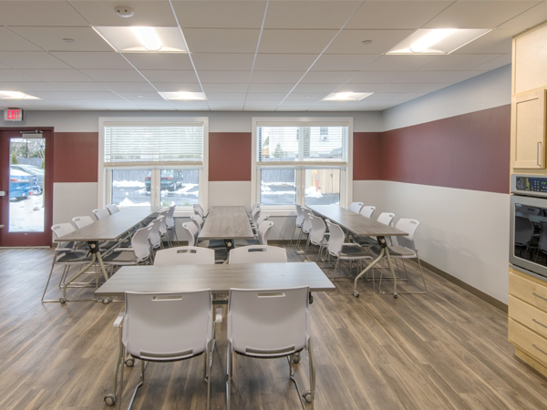 Image of an open room with arranged tables and chairs.