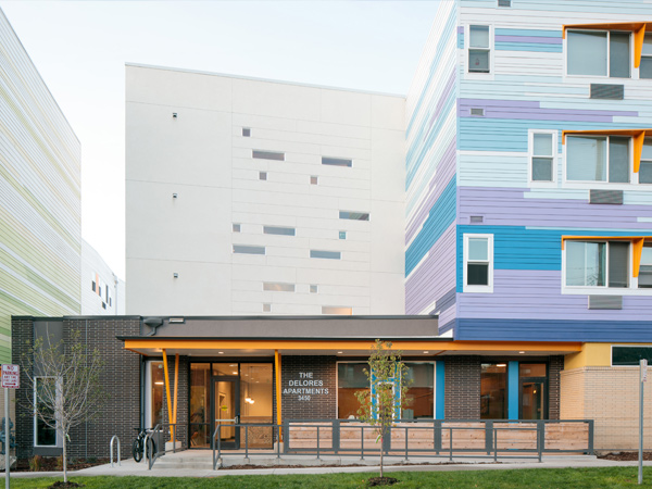  Photograph of a one-story, ramp-accessible entry to a four-story apartment building. 