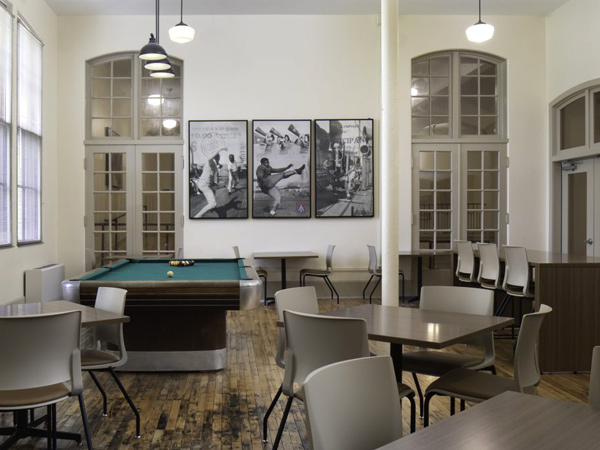 Photo of a large room with chairs around tables and a large pool table.