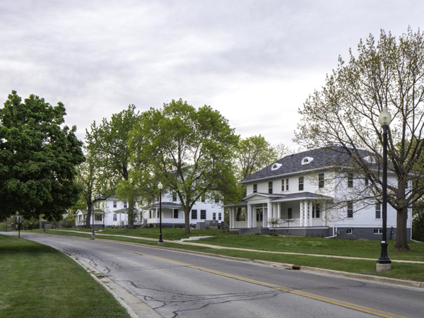 Photo of three two-story homes on a tree lined street.