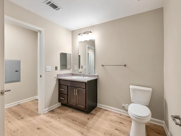 In-unit bathroom with a toilet, a vanity, and a mirror.