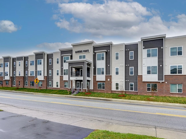 Street-level photograph of a three-story apartment building.