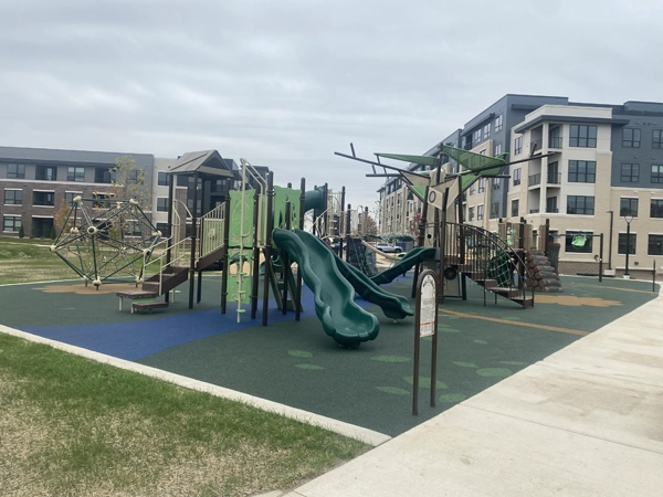 A playground in front of large apartment buildings.