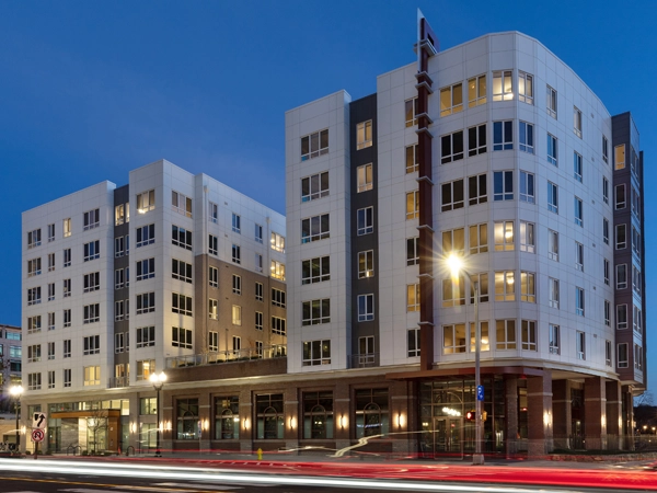 A modern seven-story apartment building on an urban street.