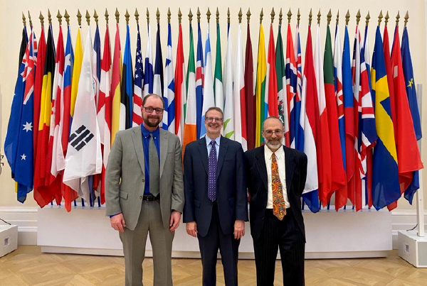 U.S. delegates standing in front of a row of flags.