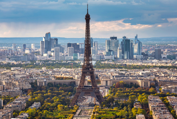 The Eiffel Tower in Paris, France, with tall buildings in the background.