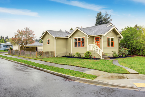 A single-story house with a lawn and driveway in front.