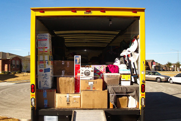 The back of an open truck filled with boxes.