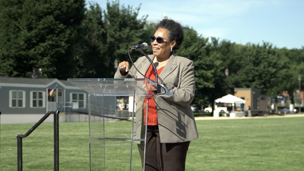 Photo of Secretary Fudge standing in front of a microphone and podium during the opening ceremony on the National Mall.