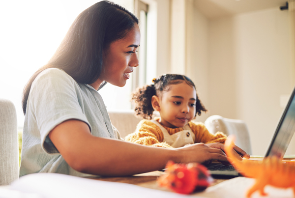 A mother and daughter using a laptop.