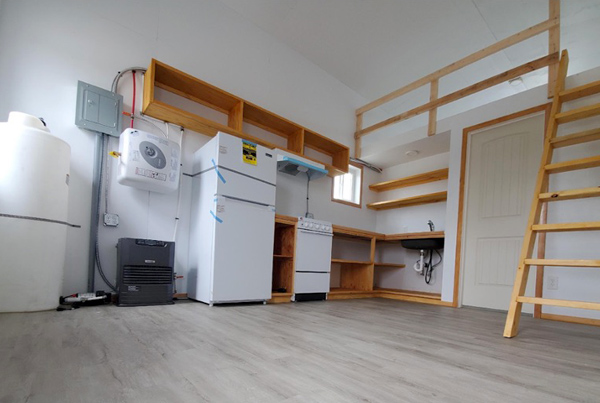 Interior of tiny apartment living room and kitchen area with loft bedroom.