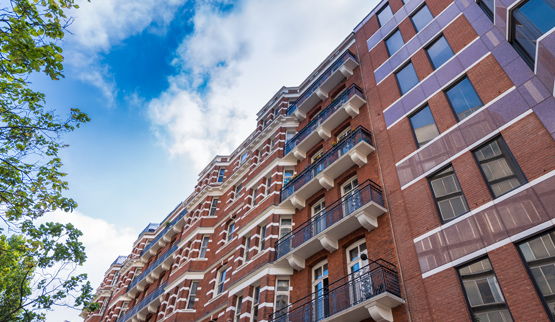 Photograph of the upper stories of three apartment buildings.