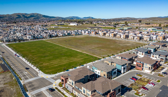 Single- and multifamily houses on three sides of an open space block.