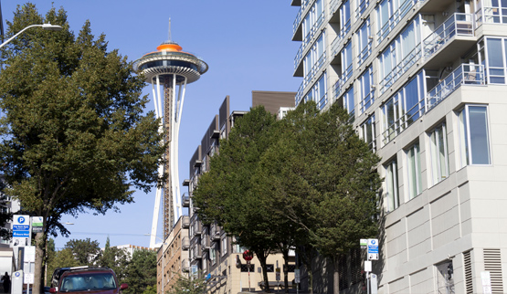 Multistory residential building, with Seattle’s Space Needle in the background.