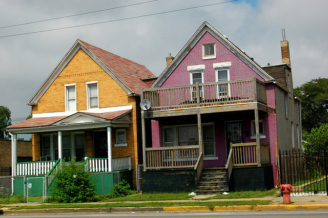 Photograph of two multi-story single family homes along a street in the Woodlawn neighborhood of Chicago, Illinois.