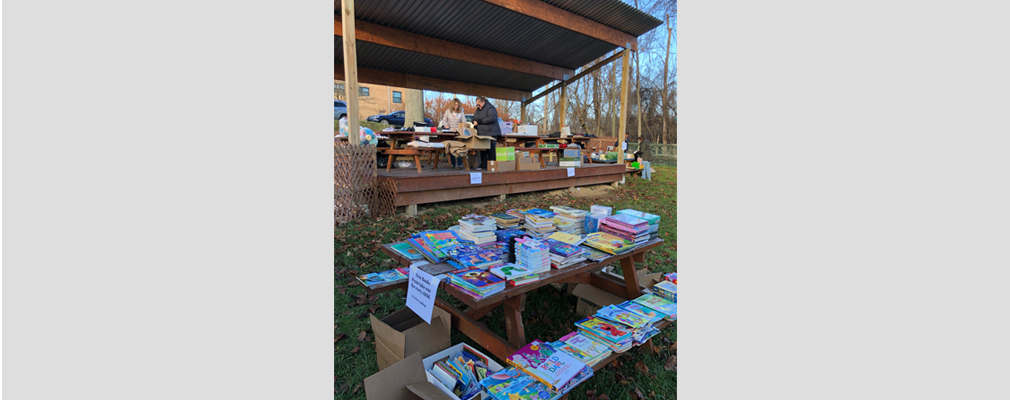 Outdoor table with numerous books. 