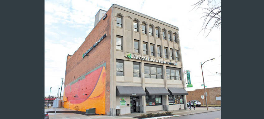 Front and side view of a four-story commercial building with the sign "Promedica Ebeid Institute" on it.
