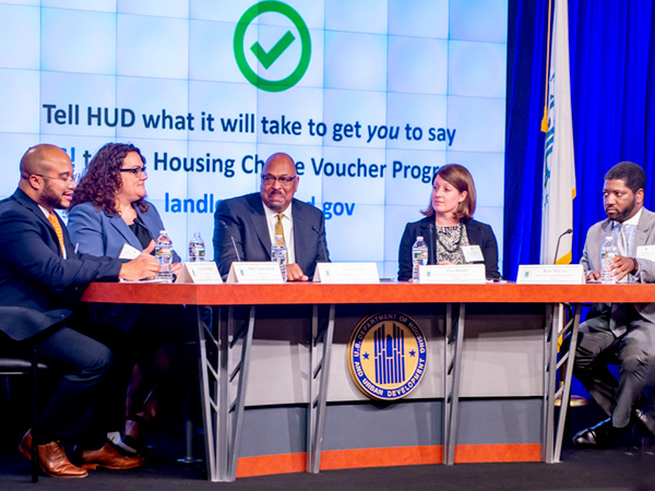 Steven Durham, director of Housing Voucher Programs in HUD’s Office of Public and Indian Housing, sits left of four seated panelists at a table bearing the HUD logo.