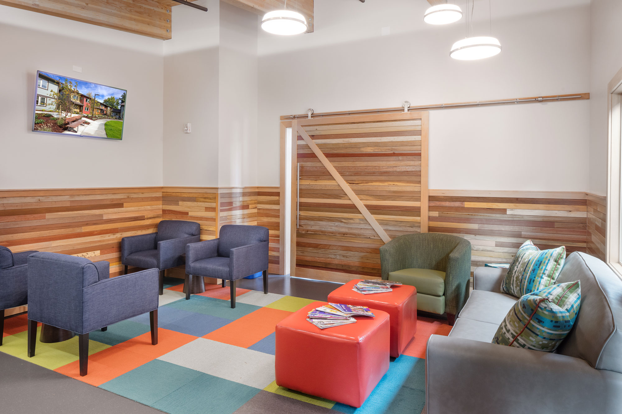 Interior seating area with a couch, chairs, and wall-mounted TV. Interior seating area with a couch, chairs, and wall-mounted TV.