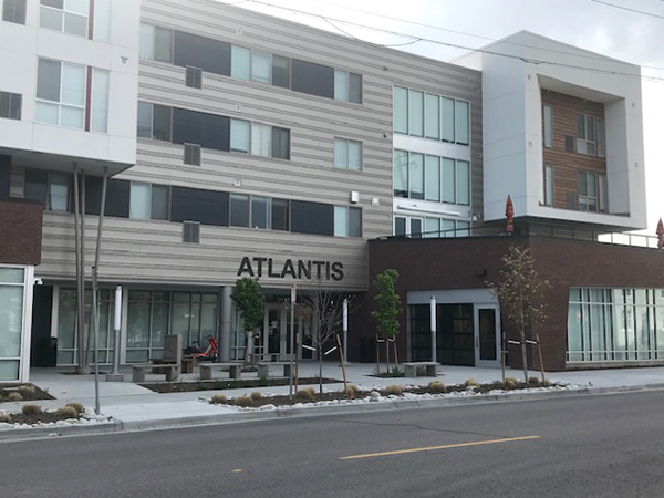 Photograph of the entrance to The Atlantis Apartments with a view of the street in the foreground and the building in the background.