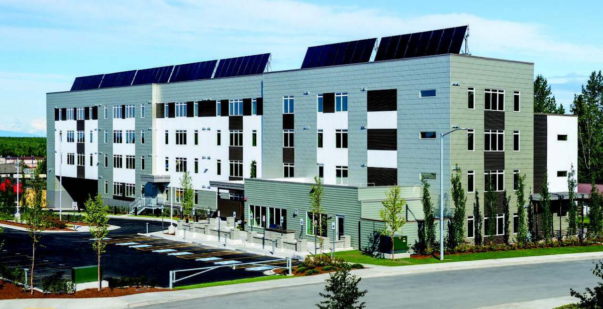 An apartment with solar panels along the roof.