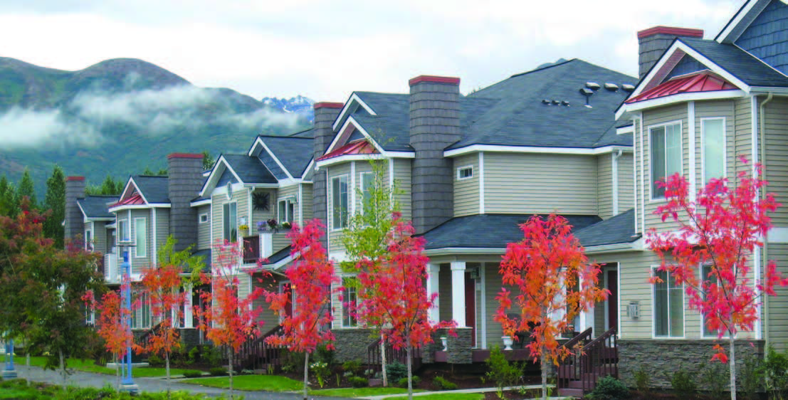 A row of homes with mountains in the background.