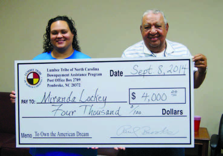A man and woman holding a large check.