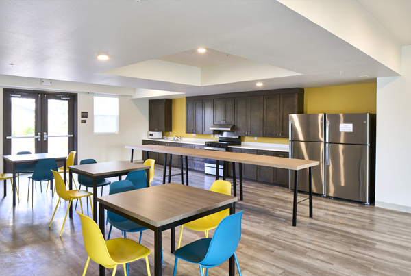 A brightly lit kitchen with multiple tables and chairs. A brightly lit kitchen with multiple tables and chairs.