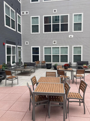 Photo of an outdoor courtyard with tables and chairs. Photo of an outdoor courtyard with tables and chairs.