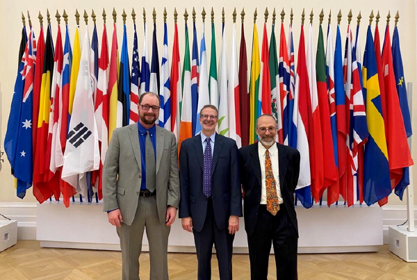 U.S. delegates standing in front of a row of flags. U.S. delegates standing in front of a row of flags.