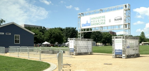 Photo of a house to the left and a large sign saying 'Innovative Housing Showcase.'