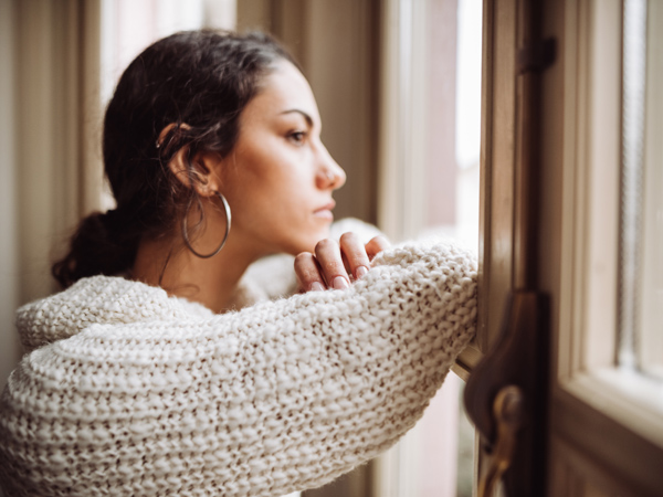 Photo of a woman looking out a window.