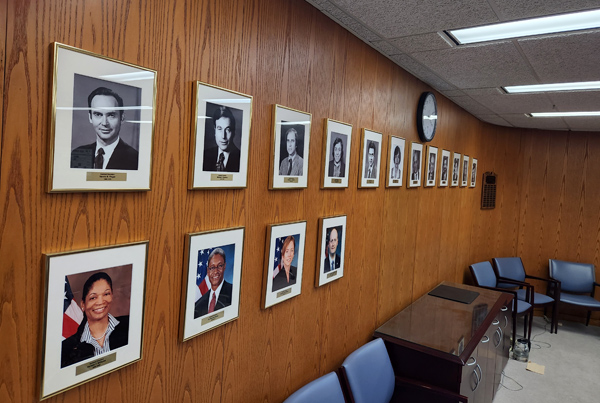 A conference room wall displaying official portraits. A conference room wall displaying official portraits.